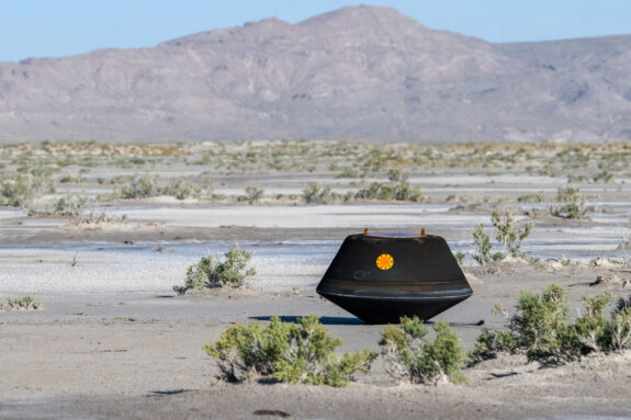 A black NASA orb-shaped capsule in the Utah desert during daytime.