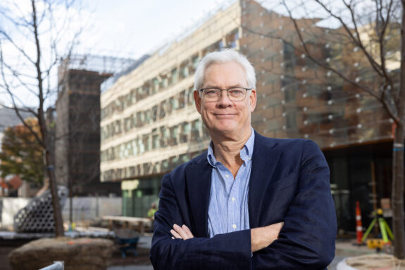 Robert Van der Drift poses in front of the Tina and Hamid Moghadam Building.