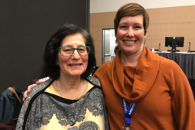 Susan Solomon and Jessica Neu stand next to each other and smile at the camera.