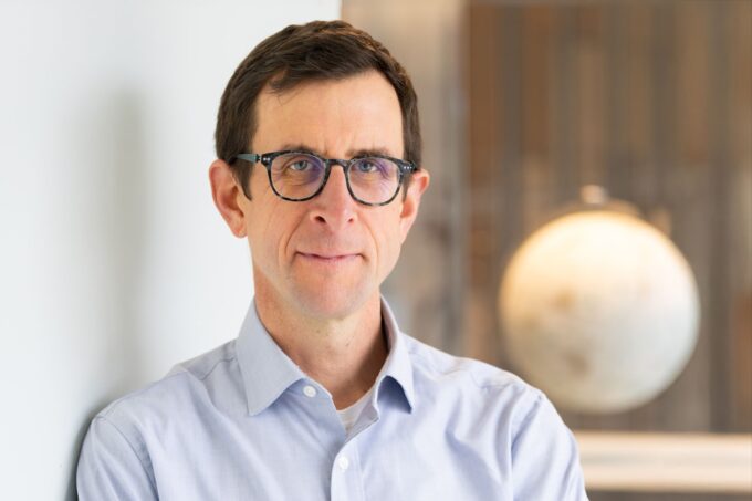 Headshot of David McGee with an out-of-focus globe in the background.